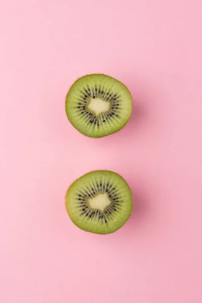 Pastel pembe bir arka plan üzerinde Yarım kesimli kivi