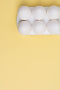 Mutlu Paskalya kavramı. Beyaz yumurta sarı arka plan üzerinde yakın. 