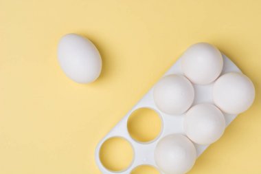 Mutlu Paskalya kavramı. Beyaz yumurta sarı arka plan üzerinde yakın. 