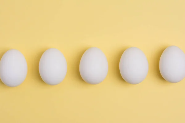 Mutlu Paskalya kavramı. Beyaz yumurta sarı arka plan üzerinde yakın. 