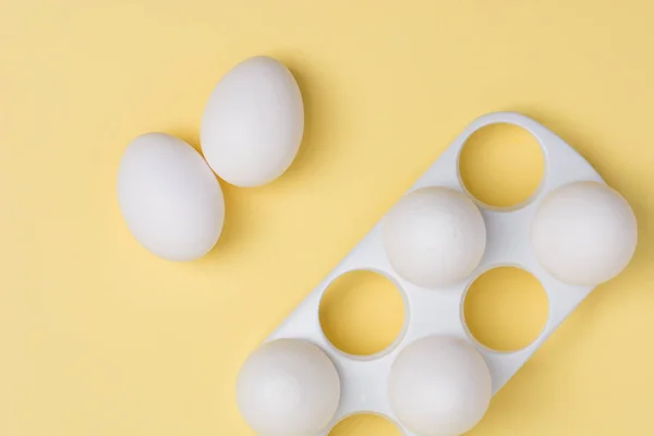 Mutlu Paskalya kavramı. Beyaz yumurta sarı arka plan üzerinde yakın. 