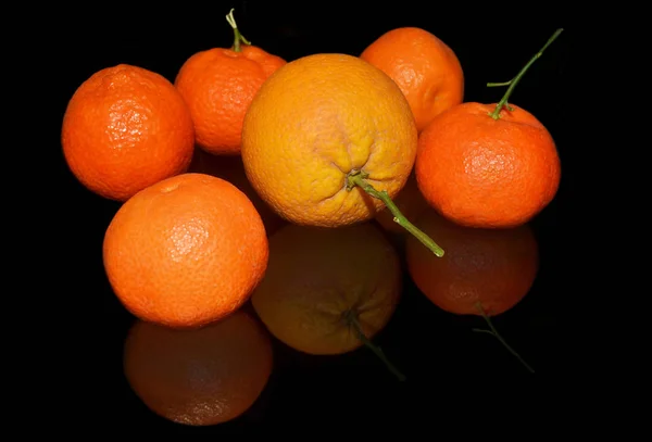 Oranges et mandarines sur fond noir — Photo