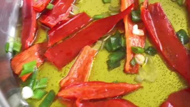 Червоний перець чилі та свіжа цибуля смажать у грецькій оливковій олії — стокове відео