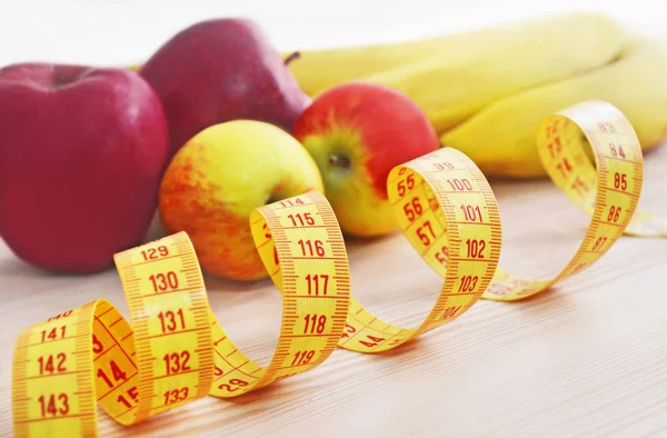 Maçãs e bananas com fita métrica - conceito de dieta — Fotografia de Stock