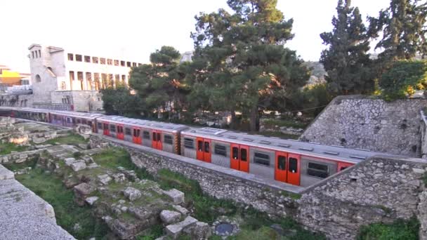 Vlak, který projíždí vlakem Thissio Athény a starověkou STOA z Attalos za — Stock video