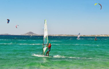 Kitesurf yapan insanlar ve Nakşa Adası Kiklad Adaları Yunanistan windsurf
