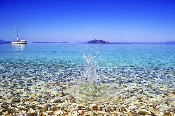 Una piedra que cae dentro del mar de la isla turquesa Grecia — Foto de Stock