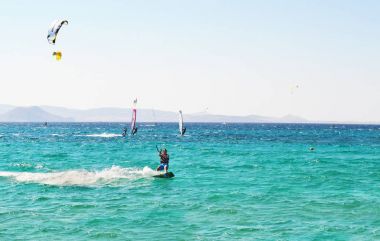 Kitesurf yapan insanlar ve Nakşa Adası Kiklad Adaları Yunanistan windsurf