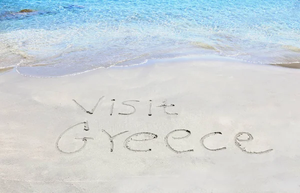 Visitar Grecia escrito en la arena — Foto de Stock