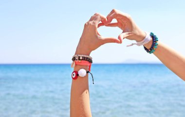 Sahilde - kalp sembol elleri ile Yunan takı reklam