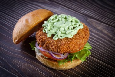 Marullu tavuk burger, domates, mor soğan ve ahşap masada el yapımı mayonez. Lezzetli.