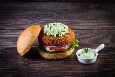 Marullu tavuk burger, domates, mor soğan ve ahşap masada el yapımı mayonez. Lezzetli.