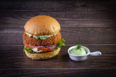 Marullu tavuk burger, domates, mor soğan ve ahşap masada el yapımı mayonez. Lezzetli.