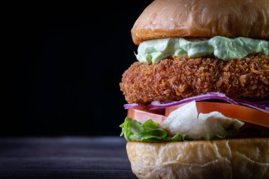 Marullu tavuk burger, domates, mor soğan ve ahşap masada el yapımı mayonez. Lezzetli.