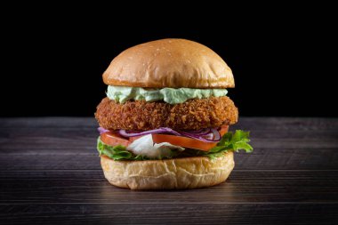 Marullu tavuk burger, domates, mor soğan ve ahşap masada el yapımı mayonez. Lezzetli.