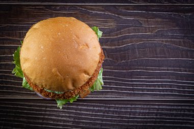 Marullu tavuk burger, domates, mor soğan ve ahşap masada el yapımı mayonez. Lezzetli.