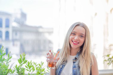 Bir kokteyl sırasında güneşli bir miktar açık içme mutlu genç kız