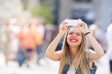 Mutlu genç bir selfie içinde açık cep telefonu ile alarak 