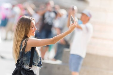 Güzel genç bir selfie içinde açık cep telefonu ile alarak