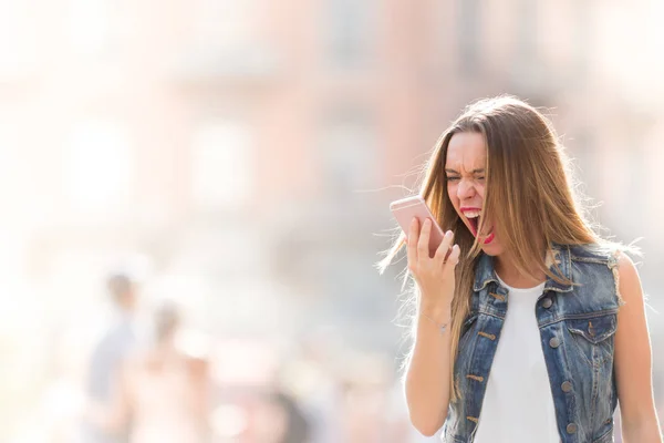 Angry and upset teenager screaming at the mobile telephone — Stock Photo, Image