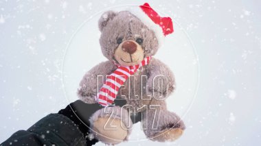 Şirin bir Noel oyuncak ayı kar karşı tutarak el 