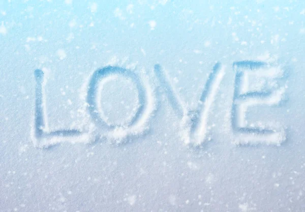 Слово "LOVE" у свіжому блакитному снігу з ефектом снігопаду — стокове фото