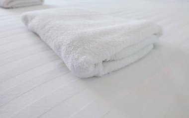 Beyaz yatak odasındaki beyaz havlu.