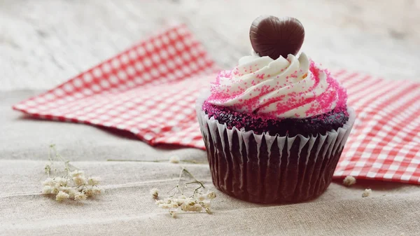 Chocolate heart on top of cupcake for valentine on old wooden ba — Stock Photo, Image