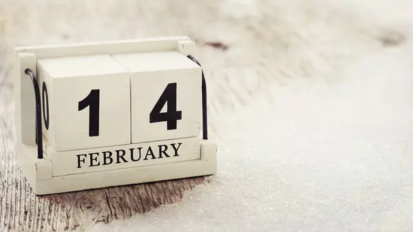 February 14 on wooden cube calendar, on wood table with snow bac — Stock Photo, Image