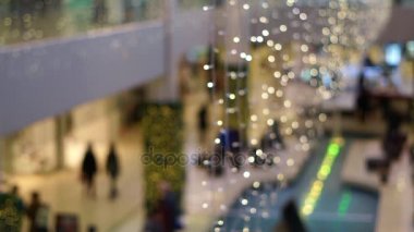 Noel dekorasyon alışveriş merkezinde yürüyen insanlarla bulanık bokeh