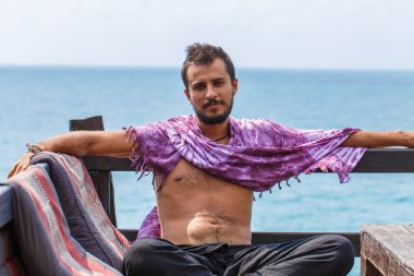 Denizin üzerinde oturan adam