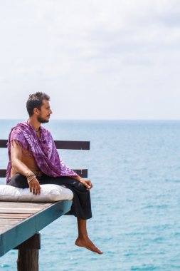 Denizin üzerinde oturan adam