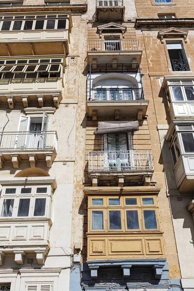 Balconies in Malta on the stone facade of historical townhouses