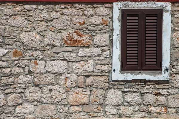 Textured wall with brown shutters