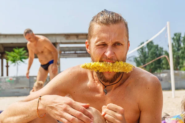 El hombre está comiendo maíz — Foto de Stock