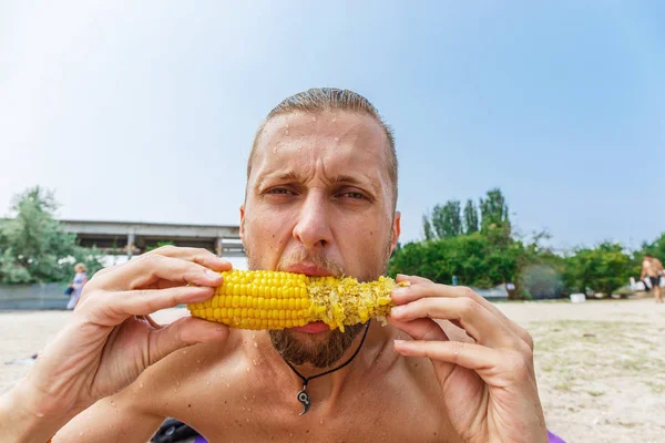 El hombre está comiendo maíz — Foto de Stock