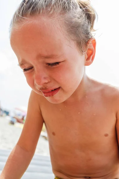 Jongen huilen op het strand — Stockfoto