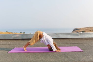 Çatıda yoga yaparken bebek