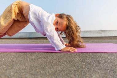Çatıda yoga yaparken bebek