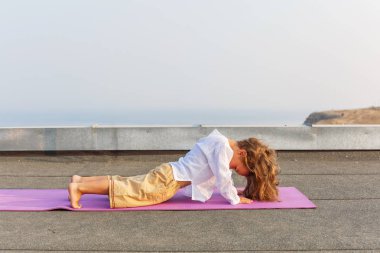 Çatıda yoga yaparken bebek