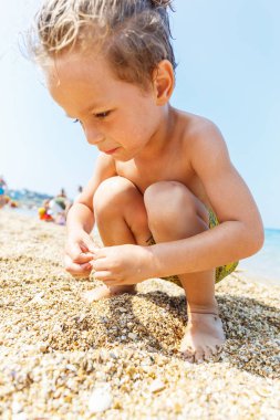 Küçük çocuk çakıl toplar