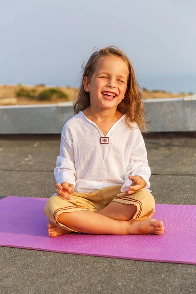 Красивый ребенок на коврике для йоги — стоковое фото