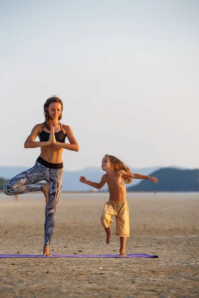 Madre con su hijo haciendo yoga — Foto de Stock