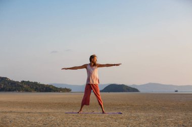 Adam sahilde yoga yapıyor