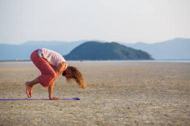 Adam sahilde yoga yapıyor