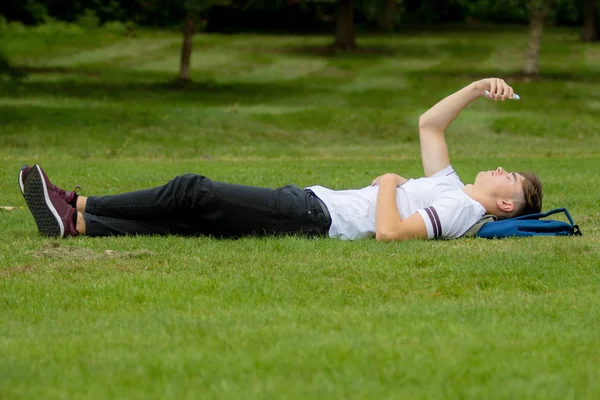 Nastoletni chłopiec r. na trawie na dzień lata — Zdjęcie stockowe