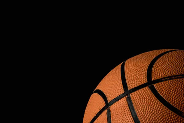 Een enkele basketbal geïsoleerd op een zwarte achtergrond — Stockfoto