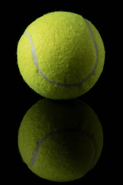 A single tennis ball isolated on a black background — Stock Photo, Image