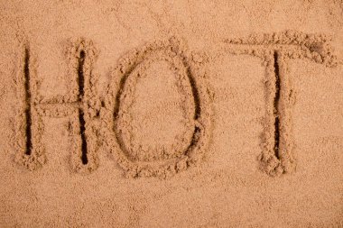 Sıcak bir kumsalda yumuşak ıslak kum çizilmiş