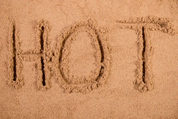 Sıcak bir kumsalda yumuşak ıslak kum çizilmiş